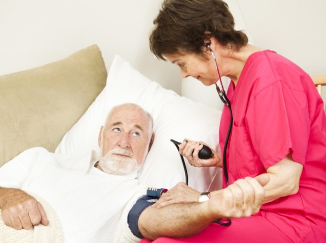 Home health care nurse taking a senior patient's blood pressure.