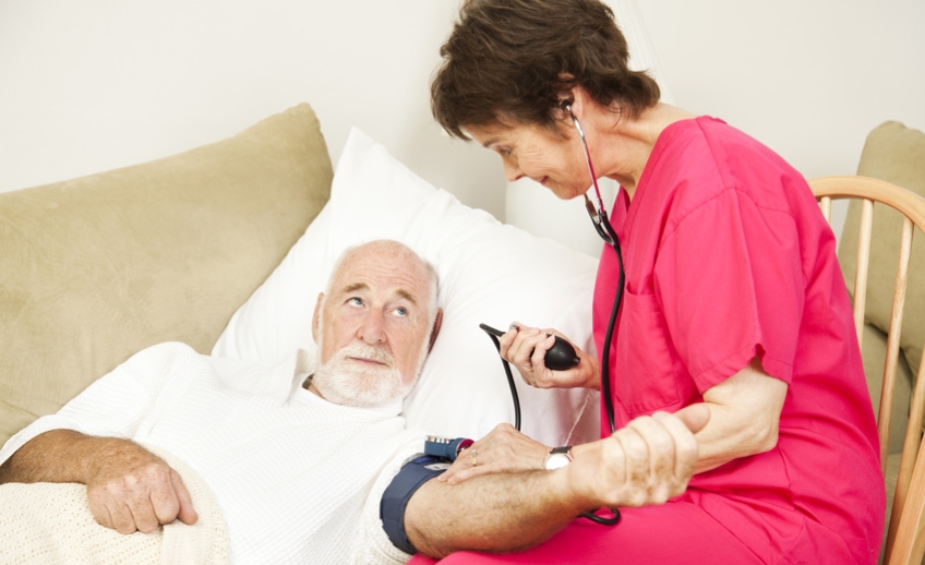 Home health care nurse taking a senior patient's blood pressure.